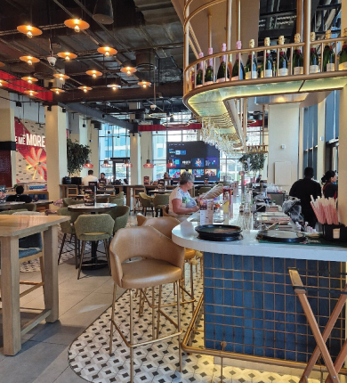 Vibrant TGIF restaurant interior at Rove Hotel Dubai featuring custom Thüraia pendant lights and American-style bar area with warm ambient lighting